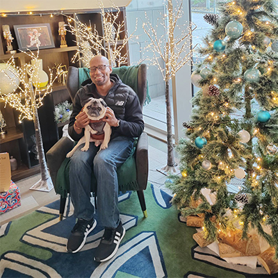 Barney and Carlton sitting on chair by Christmas treet